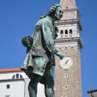 Popis: Piran a socha rodáka Giuseppe Tartiniho, vzadu kostel se zvonicí