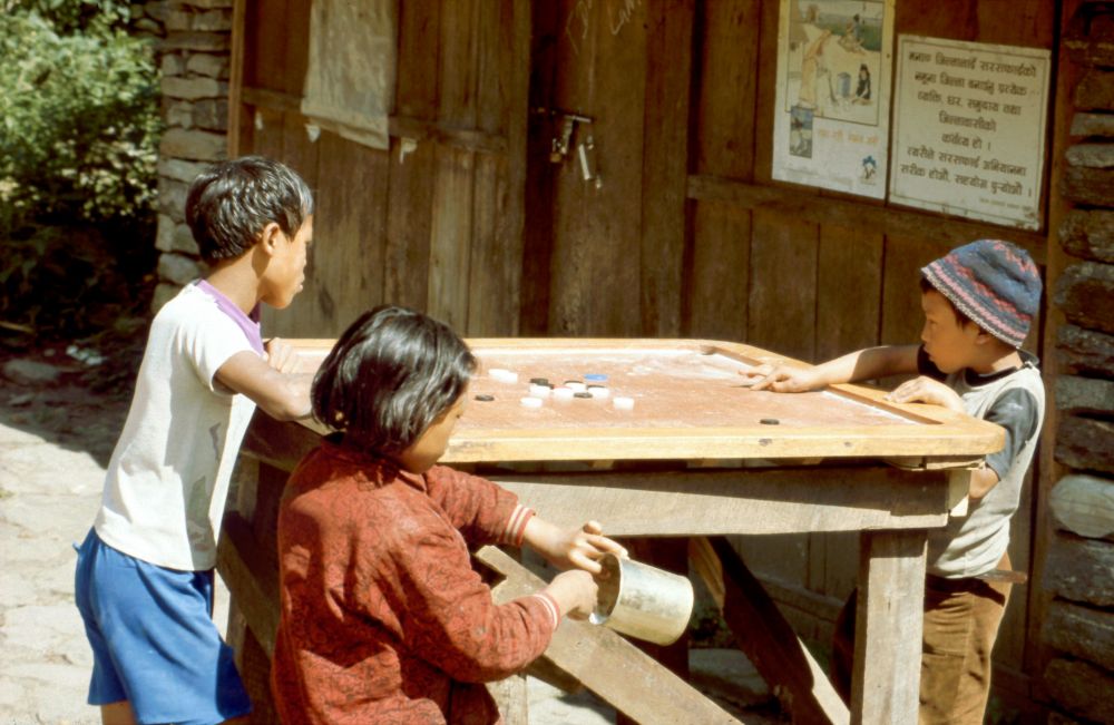 Nepálská mládež hraje velmi populární hru Karrom