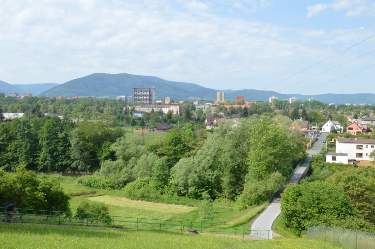 Průmyslový Třinec schovaný v zeleni, vzadu kopec Javorový