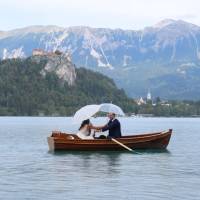 Popis: jezero Bled, svatba za deště, vzadu Karavanky